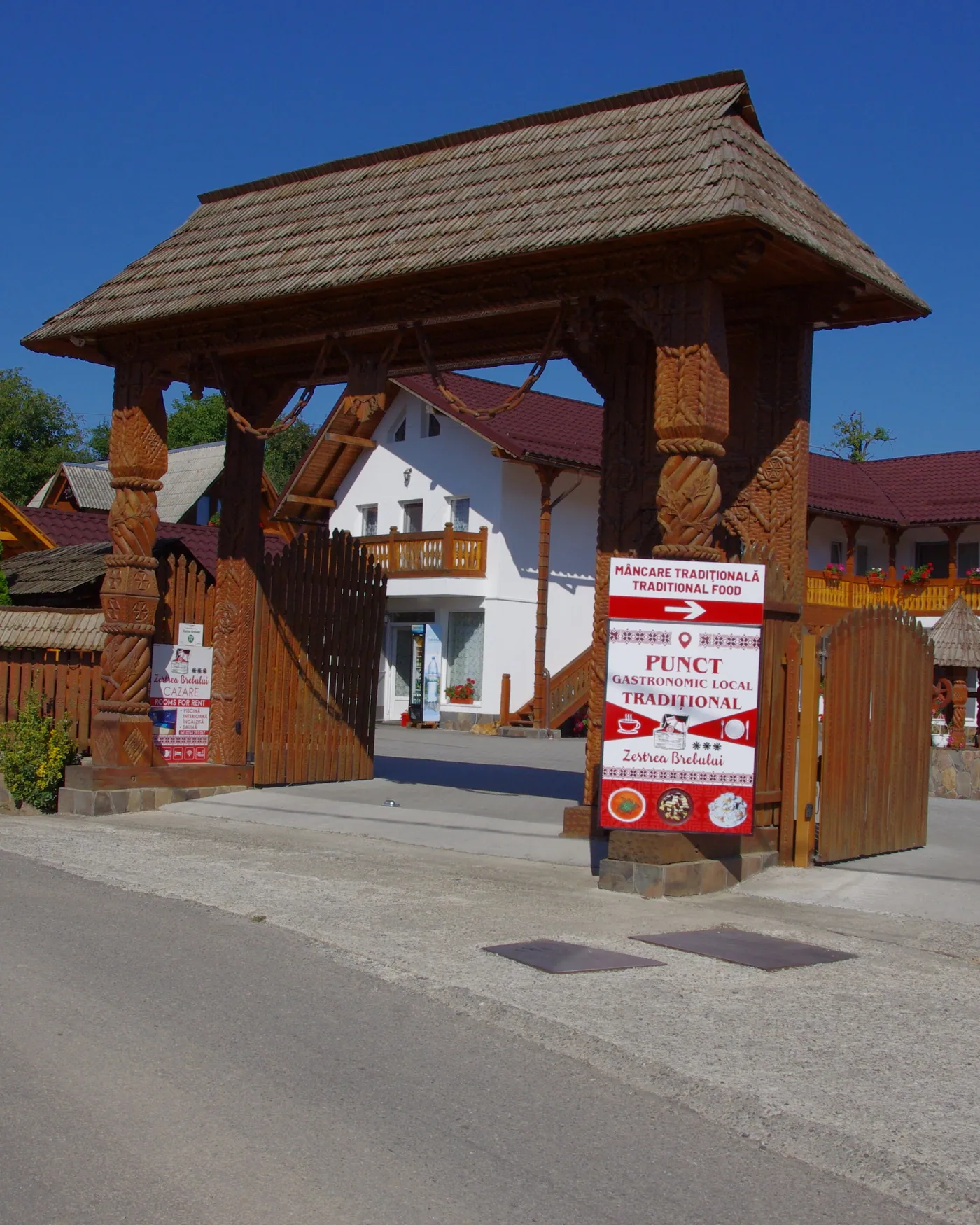Poarta de lemn sculptat de la intrarea în pensiunea Zestrea Brebului