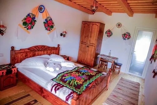 Room with a wooden bed and a blanket with traditional patterns