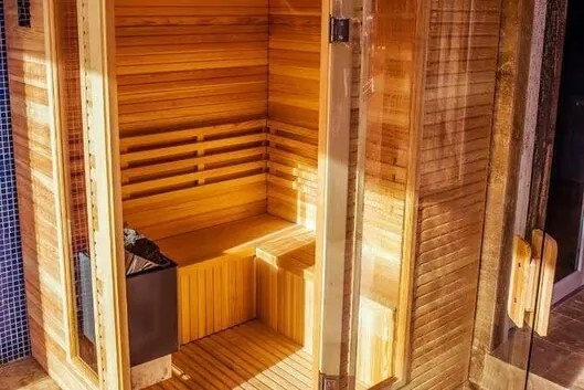 Wooden sauna with a bench and a glass door